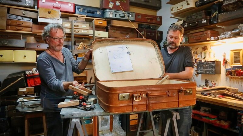 Die Koffer-Experten Dominikus Probst (l) und Laurenz Buchholz haben mit einem alten Reisekoffer zu kämpfen. – Bild: WDR/​Encanto Film- und Fernsehproduktions GmbH