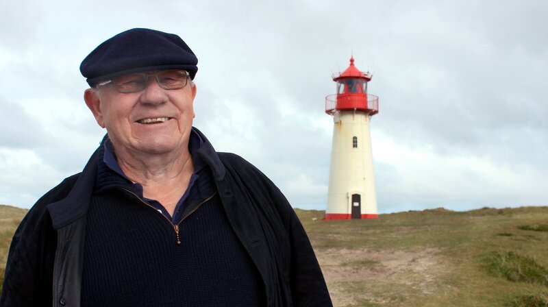 Armin vor dem weißen Leuchtturm List West auf der Sylter Halbinsel Ellenbogen. – Bild: WDR/​FLASH Film