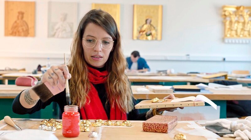 Cindy Reimers lernt in der Vergolderschule mit dem filigranen Werkstoff umzugehen. – Bild: BR/​Tangram International GmbH/​Markus Dörnberger