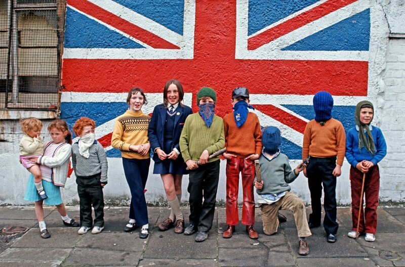 Kinder aus einem Viertel protestantischer Unionisten in Belfast vor einem Wandbild mit der Flagge des Union Jack, Nordirland, 1971. – Bild: phoenix/​ZDF/​Bridgeman/​Alain Le Garsmeur