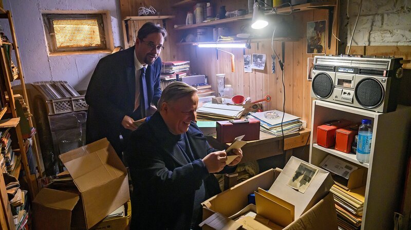 Stöbern im Keller nach Spuren aus Boernes Kinderheit: Prof. Karl-Friedrich Boerne (Jan Josef Liefers) und Frank Thiel (Axel Prahl) wühlen sich durch alte Kisten. – Bild: WDR/​Willi Weber