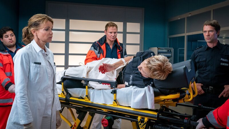 Melanie (Sanna Englund, M.) wurde im Einsatz verletzt. Mattes (Matthias Schloo, r.) und Jasmin (Gerit Kling, l.) machen sich Sorgen um ihr ungeborenes Kind, von dem Haase (Fabian Harloff, 2.v.l.) noch nichts weiß. – Bild: ZDF und Boris Laewen