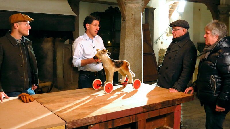 Moderator Oli P. (l), Hans Meyer (2.v.r.) und Renate Bauer treffen in der Holzwerkstatt auf den Experten Marcel Offermann (2.v.l.), der ihren alten Steiff-Hund begutachtet. – Bild: WDR/​Encanto Film- und Fernsehproduktions GmbH
