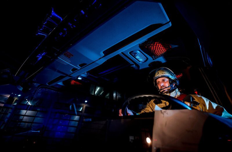 Ein Feuerwehrmann der Berufsfeuerwehr Duisburg am Steuer eines Einsatzfahrzeugs. Noch vor Morgengrauen geht die Meldung ein: Rauchentwicklung in einer Wohnsiedlung. Die Spur führt schließlich auf ein riesiges, verlassenes Fabrikgelände – überwuchert und dunkel. – Bild: WDR/​Sebastian Drolshagen