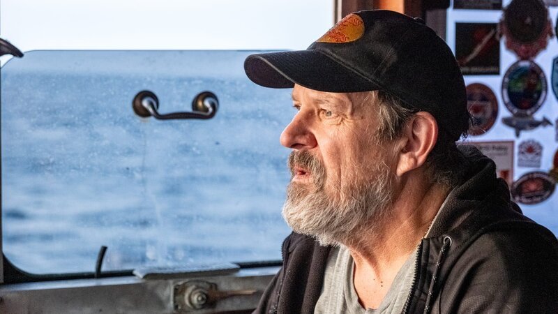 Close up side profile of Wizard co-captain Monte Colburn at the helm – Bild: Warner Bros. Discovery, Inc. or its subsidiaries and affiliates