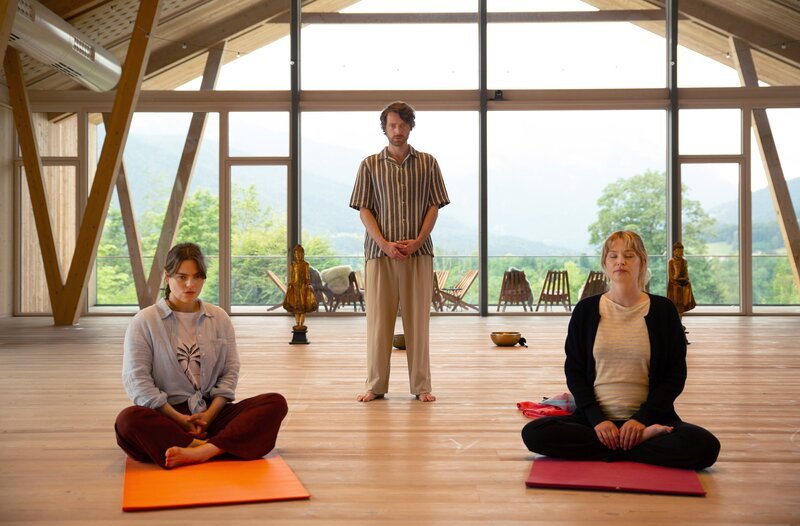 Nach dem Tod des Leiters eines Meditationszentrums besucht Johanna Beissl (Vanessa Eckart, r.) undercover ein Seminar, um mehr über den Kursleiter Konstantin Wahler (Maximilian Klas, m.) und die Teilnehmerin Tamara Echternacht (Luise Deborah Daberkow, l.) herauszufinden. – Bild: ARD/​BR/​Lucky Bird Picturess/​Christoph Krauth