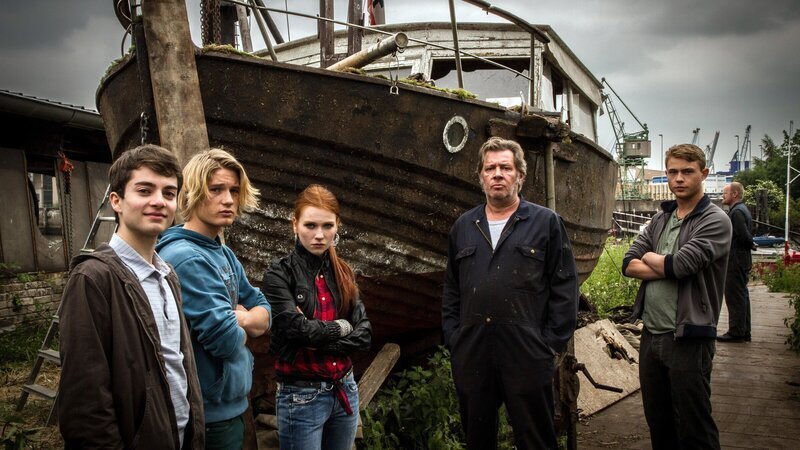 Arne (Max Hegewald) mit seiner neuen Familie, Lars (Sven Gielnik), Wiebke (Franziska Brandmeier), Harald (Jan Fedder) und Hans (Dennis Mojen) vor der Werft. – Bild: ZDF und NDR/​Hannes Hubach