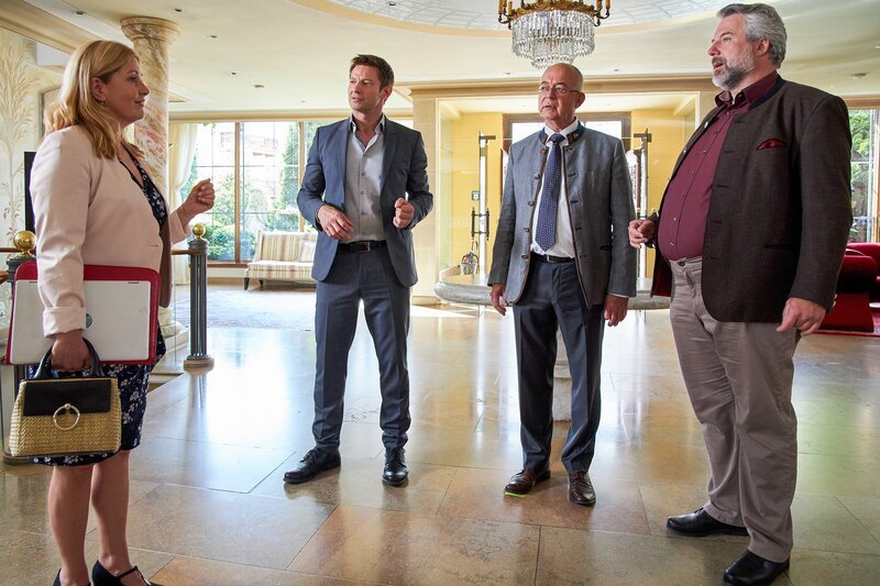 Polizeichef Achtziger (Alexander Duda, 2.v.r.) und Marie (Karin Thaler, l.) sind überrascht, die Kommissare Stadler (Dieter Fischer, r.) und Hansen (Igor Jeftić, 2.v.l.) dienstlich im Hotel Sonnenblick anzutreffen. – Bild: Bojan Ritan /​ ORF /​ ZDF