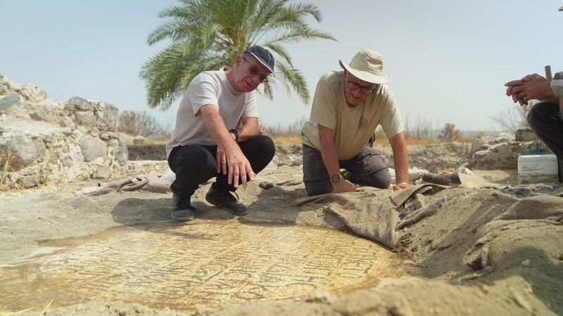 Dr. Mordechai Aviam zeigt Professor Jacob Ashkenazi eine kürzlich entdeckte Mosaikinschrift an der archäologischen Stätte von El Araj. – Bild: Windfall Films