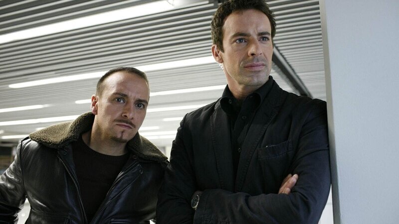 Semir (Erdogan Atalay, li.) und Chris (Gedeon Burkhard) fahnden nach dem Afrikaner Xolani Mogwaza, dessen Spur sie zu einem Mann aus Chris’ Vergangenheit führt … – Bild: RTL