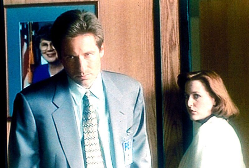 Mulder (David Duchovny) und Scully (Gillian Anderson) verdächtigen ihren Chef, von einer Konspiration zwischen der Regierung und der pharmazeutischen Firma gewusst zu haben, die 18 Menschen das Leben gekostet hat. – Bild: ProSieben MAXX