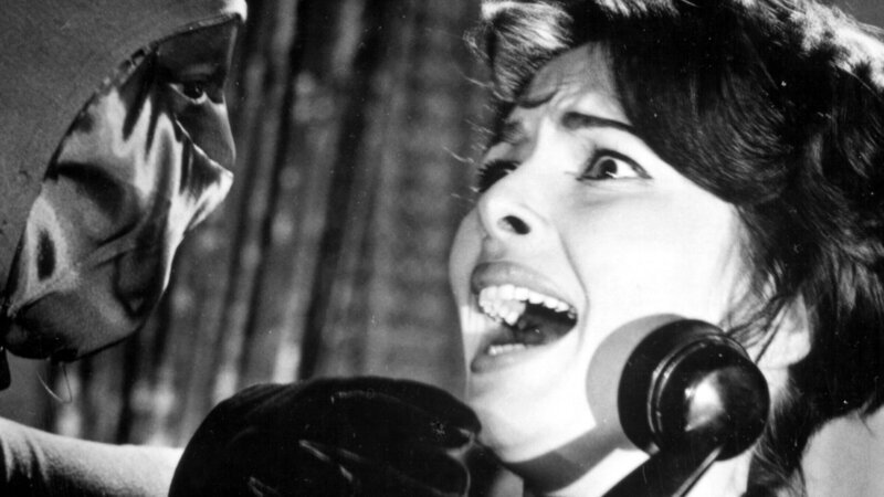 Valerie Howett (Karin Dor) wird von dem maskierten Bogenschützen beim Telefonat überrascht und bedroht. – Bild: ZDF und Lilo Winterstein