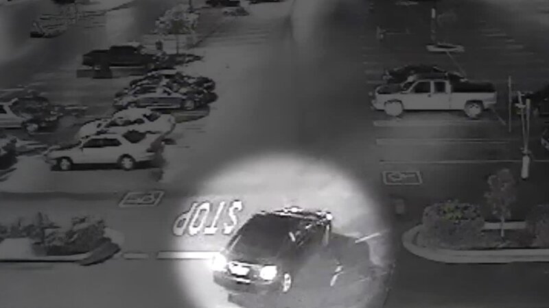 Eine nächtliche Überwachungsaufnahme zeigt ein Fahrzeug, das an einer ‚STOP‘-Markierung auf einem Parkplatz vorbeifährt. – Bild: Crime + Investigation /​ A+E Global Media