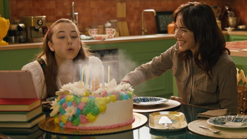 Lucy (Kensington Tallman, l.) pustet die Kerzen auf ihrem Einhorn-Geburtstagskuchen aus. – Bild: hr/​Red Monk Studios srl/​ HSR S1 (FGM) Inc.