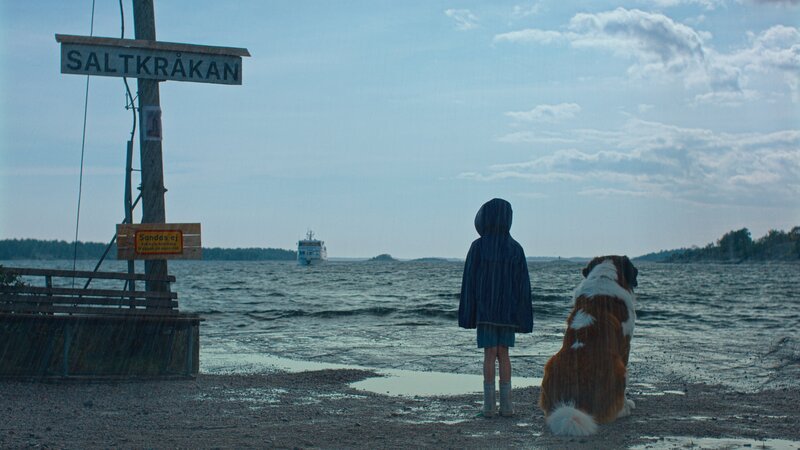 Tjorven (Vega Åhman) und ihr Hund Bootsmann stehen geduldig am Anleger der Fähre und erwarten die neuen Feriengäste auf Saltkrokan. – Bild: ZDF und Robert Eldrim-SF studios