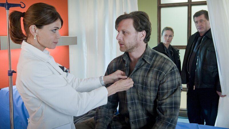 Offensichtlich findet Dr. Jasmin Jonas Gefallen an dem verletzten Chef der Reiterstaffel Christian Olsen. Franzi und Hans beobachten das. – Bild: ZDF und Boris Laewen