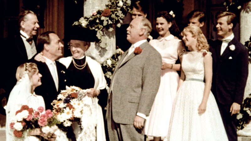 Onkel Pankraz (Hans Nielsen, Mitte) gratuliert seiner Tochter Margot (Karin Andersen, li.) zu ihrer Hochzeit mit Jochen von Roth (Paul Kliner, 3. v. re.). Der reiche Winzer hat außerdem Oma Jatzens (Margarethe Haagen, 4. v. li.) Immenhof gerettet. Die Zukunft von deren Enkeln Dick (Angelika Meissner-Voelker) und Dalli (Heidi Brühl, re.) ist damit gerettet. Cousin Ethelbert (Matthias Fuchs, re.) hatte an dieser Rettung maßgeblichen Anteil. – Bild: ZDF und ARD Degeto Onkel Pankraz (Hans Nielsen, Mitte) gratuliert seiner Tochter Margot (Karin Andersen, li.) zu ihrer Hochzeit mit Jochen von Roth (Paul Kliner, 3. v. re.). Der reiche Winzer hat außerdem Oma Jatzens (Margarethe Haagen, 4. v. li.) Immenhof gerettet. Die Zukunft von deren Enkeln Dick (Angelika Meissner-Voelker) und Dalli (Heidi Brühl, re.) ist damit gerettet. Cousin Ethelbert (Matthias Fuchs, re.) hatte an dieser Rettung maßgeblichen Anteil. – Bild: ZDF und ARD Degeto