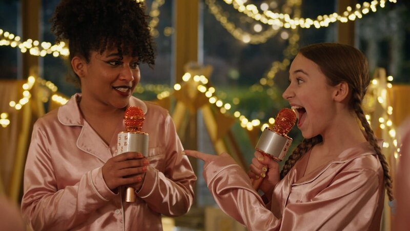 Charlotte (Gloria Colston, l.) und Lucy (Kensington Tallman, r.) singen Karaoke im Pyjama. – Bild: hr/​Red Monk Studios srl /​ HSR S1 (FGM) Inc.