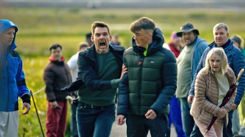 An einer touristischen Attraktion versucht Huldar (Kolbeinn Arnbjörnsson, 3.v.l.), einen flüchtigen Verdächtigen aufzuhalten. – Bild: WDR/​Jóhann Máni Jóhannsson