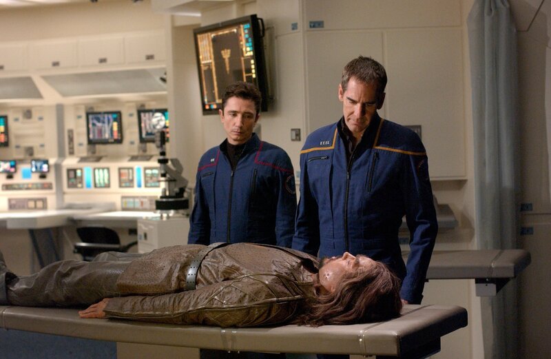 Reed (Dominic Keating, l.) und Archer (Scott Bakula, r.) sorgen sich um Marab (Terrell Tilford, liegend), der an einem tödlichen Virus erkrankt ist … – Bild: Paramount Pictures /​ SYFY