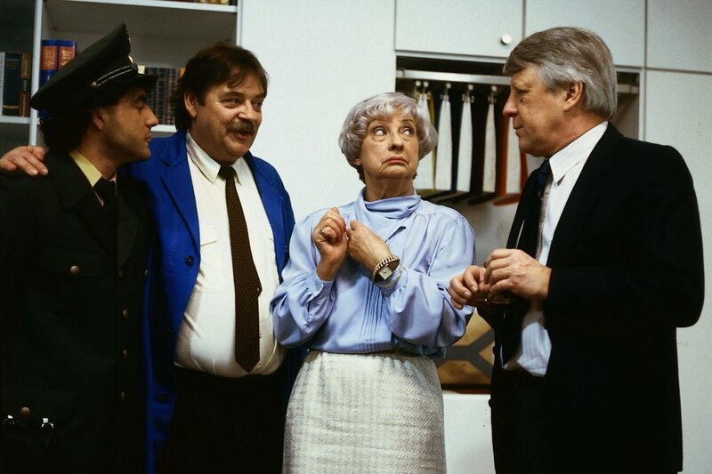 4. Eberhard (Stefan Orlac, re.), Frl. Glaubrecht (Gudrun Genest) und Werkmeister Heinz (Andreas Mannkoff, 2.v.li.) bestaunen Karim II (Yüksel Yolci, li.) als frischgebackenen Polizeibeamten. – Bild: ZDF und Terranova