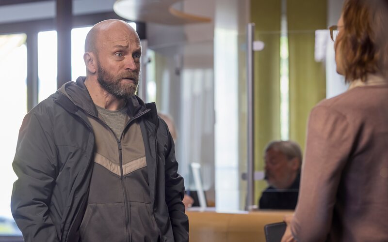 Fredrik (Joakim Sällquist) ist verärgert, weil die Ermittlungen im Fall seines verschwundenen Sohnes Benjamin wieder eingestellt werden sollen. Er diskutiert mit Polizistin Kerstin (Kajsa Ernst) darüber. – Bild: ZDF und Carolina Romare