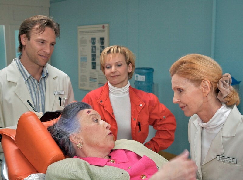 Christel Petry (Regine Lutz, liegend) wird nach einem Sturz mit einer komplizierten Armfraktur in die Sachsenklinik eingeliefert. Christel Petry wird von Dr. Stein (Bernhard Bettermann, li.) und Dr. Globisch (Andrea Kathrin Loewig, 2.v.li.) aufgenommen und kennt Oberschwester Ingrid (Jutta Kammann, re.) – Bild: MDR/​Krajewsky