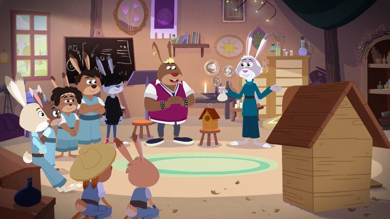 Bei Hermine stehen Holzarbeiten auf dem Programm. Chester, Kela, Calloway, Sally, Hansi, Anton, Franzi und Emmi lauschen gespannt. – Bild: KiKA/​Sixteen South & Letko