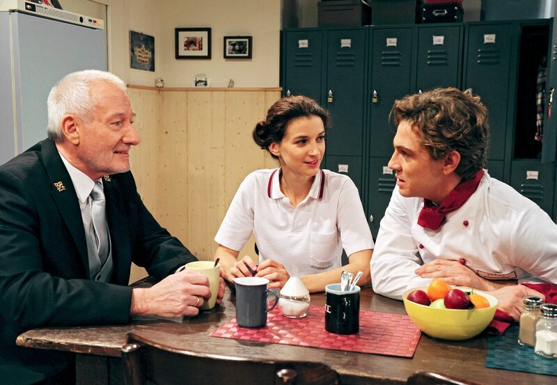 Elena (Lili Gesler, M.) und Alfons (Sepp Schauer, l.) freuen sich, dass Christian (Leander Lichti, r.) im Chor mitmachen will. – Bild: ARD/​Ann Paur