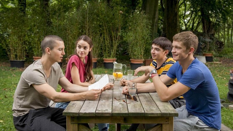 V.l.: Leo (Tim Oliver Schultz) entdeckt seine alte „Bucket List“ wieder, die er als kleiner Junge geschrieben hat. Als er Emma (Luise Befort), Toni (Ivo Kortlang) und Jonas (Damian Hardung) davon erzählt, beschließen sie, die Liste gemeinsam abzuarbeiten. – Bild: TV NOW /​ Martin Rottenkolber