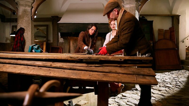Die Holzexperten Heiko Wussow (r) und Marcela Holzhausen (l) zerlegen zusammen mit Victoria (m) ein altes Scheunentor. – Bild: WDR/​Encanto Film- und Fernsehproduktions GmbH