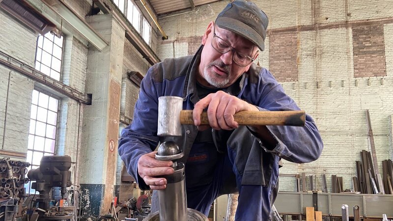 Peter hammers new ball into the dumper press – Bild: Warner Bros. Discovery, Inc. /​ Bea Reinecke