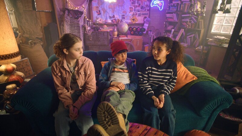 Malin (Ida Carlo, li.), Piet (Noah Lusander) und Taara (Josefine Maxima, re.) überlegen im HQ, wer den Wasserschaden verursacht haben könnte. – Bild: NDR/​Letterbox