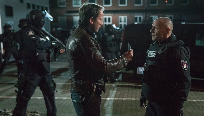 NDR Fernsehen TATORT: FROHE OSTERN, FALKE, am Montag um 20:15 Uhr. Falke (Wotan Wilke Möhring) weist sich vor dem SEK-Einsatzleiter (Torsten Michaelis) aus. – Bild: NDR/​Christine Schroeder