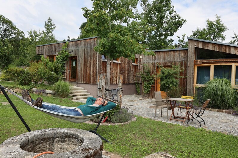 Hubert Baumgartner in der Hängematte im Altholzchaletdorf während ServusTVs „Bei mir Daheim“ in Inzersdorf, OÖ. – Bild: ServusTV /​ Terra Mater Studios /​ Priska Adlassnig /​ Terra Mater Studios GmbH