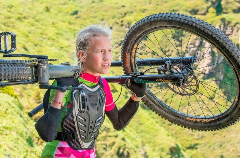 Madison (Felice Ahrens) muss unfreiwillig auf das Mountainbike umsteigen, was ihren Alltag ziemlich durcheinander bringt. – Bild: MDR/​KiKA/​DOR Film-West/​Stefanie Leo