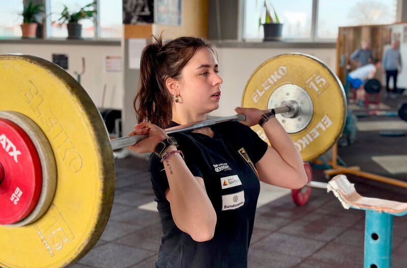 Wie fühlt es sich an, jeden Tag in einer Arbeitswelt zu bestehen, in der man auffällt, bevor man überhaupt etwas sagt? Die Reportage erzählt von Frauen, die Jobs haben, die auch 2026 fest in männlicher Hand sind – Frauen aus der Region, die sich bewusst gegen immer noch existierende Rollenbilder entschieden haben. – Gewichtheberin Antonia Ackermann beim Training. – Bild: rbb/​Stefanie Stoye