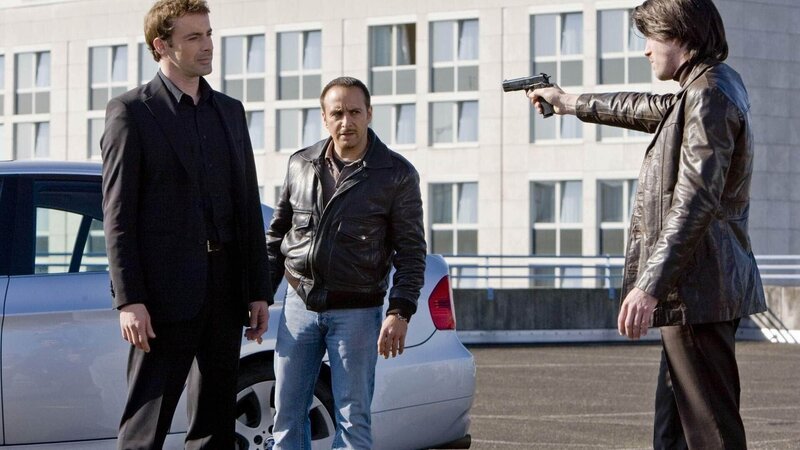 Chris (Gedeon Burkhard, li.) und Semir (Erdogan Atalay, 2.v.li.) ziehen den eingefädelten Deal durch und liefern bei Sanders Schergen (re. Nic Fromm) das Rauschgift ab. – Bild: MG RTL D /​ Guido Engels