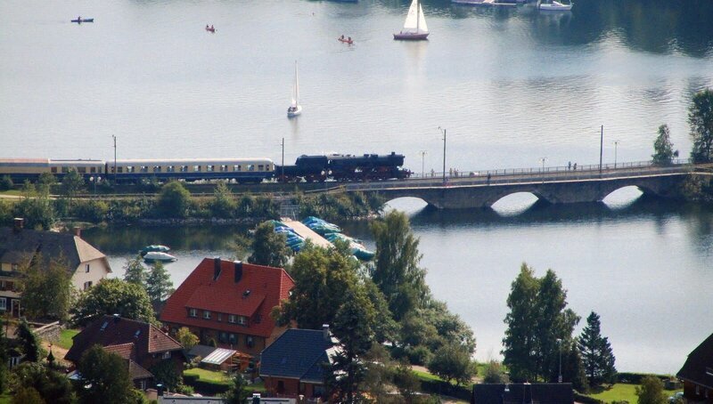 Der Dampfsonderzug der 3-Seen-Bahn überquert das einzige Vidadukt der Hochschwarzwaldstrecke beim Ort Schluchsee. Bis in die 30er Jahre waren die Pfeiler über 30 m hoch; durch die Aufstauung des Schluchsees verschwand die Brücke fast. Regelmäßig im Sommer und zum Jahreswechsel fährt der Dampfzug auf der 19 km langen Strecke für Touristen wie vor 60 Jahren. – Bild: SWR/​Bernhard Foos