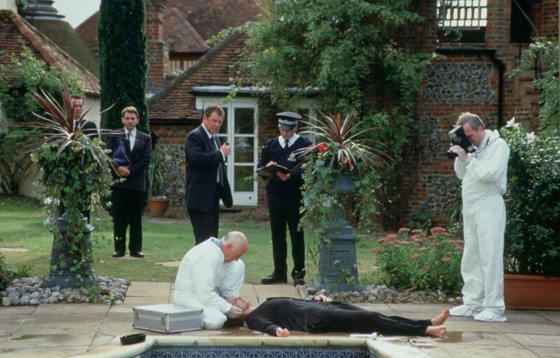 Stehend, M.: DCI Tom Barnaby (John Nettles), in der Hocke: Dr. Bullard (Barry Jackson), liegend: Ginny Sharp (Serena Gordon) – Bild: ZDF