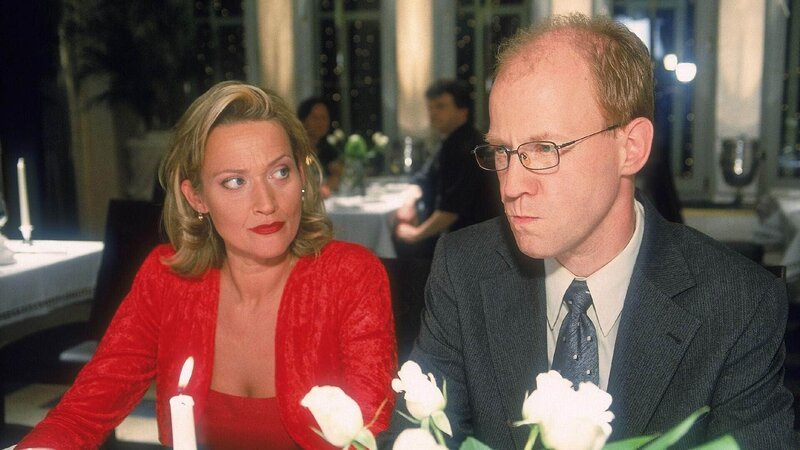 Schumann (Lutz Herkenrath) und Rita (Gaby Köster) geben sich als liebendes Ehepaar aus, weil Schumann glaubt, dadurch bessere Beförderungschancen bei Blattgerste zu haben. – Bild: MG RTL D