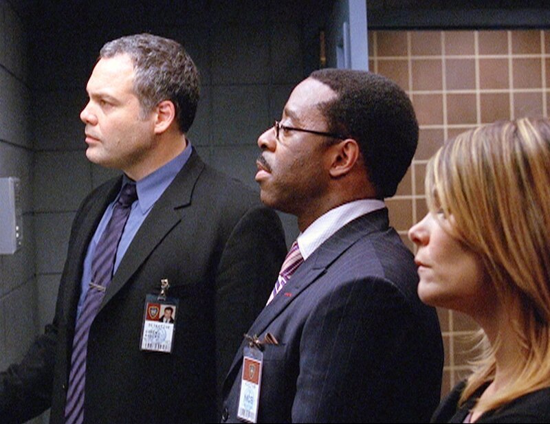 Goren (Vincent D’Onofrio, l.), Carver (Courtney B. Vance) und Eames (Kathryn Erbe) verfolgen hinter einem Spiegelglas eine Zeugenaussage. Können Sie einen Mörder endlich dingfest machen? – Bild: 13th Street
