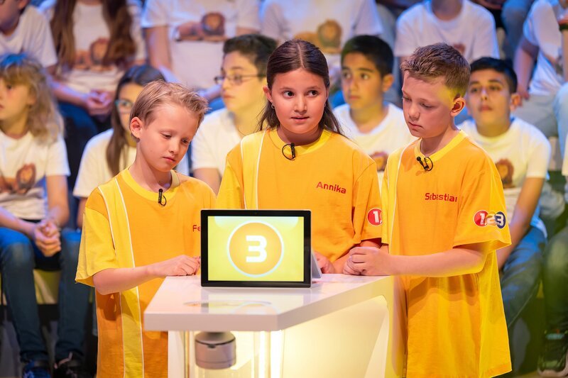 Das gelbe Rateteam aus der Wiener Neustadt/​Österreich rätselt über eine von Eltons spannenden Quizfragen. – Bild: ZDF/​Ralf Wilschewski