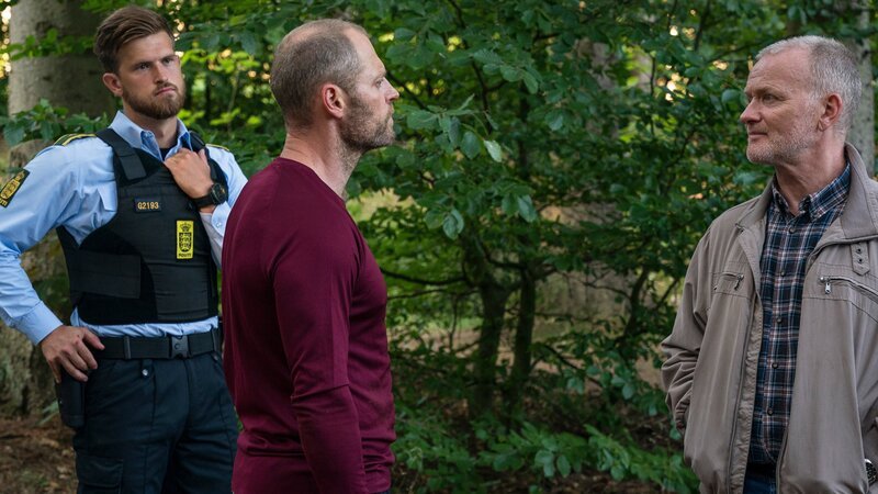 Polizist Grube (Bue Wandahl, r.) und ein Kollege (Komparse, l.) befragen Niels (Jacob Lohmann, M.) zum Tod des Schlossbesitzers Corfitzen. – Bild: ZDF und Mike Kollöffel
