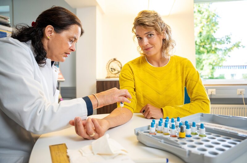 Prof. Dr. Claudia Traidl-Hoffmann testet Lena Ganschow mittels Pricktest auf Allergien am Universitätsklinikum Augsburg. – Bild: MDR/​InOneMedia/​Albrecht Elstermann