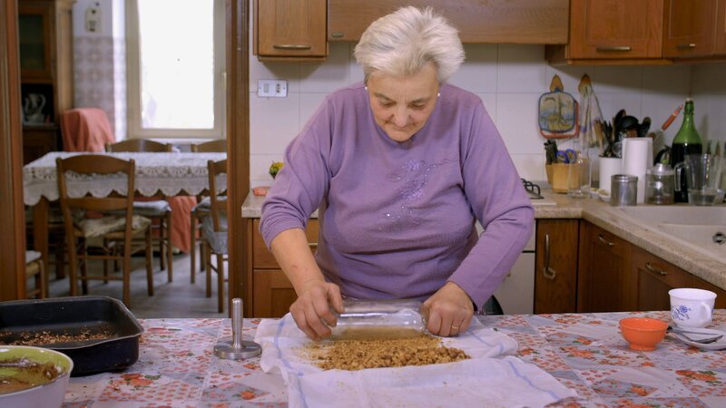 Oma Maria zerkleinert die Haselnüsse.; Köstliches Italien – Die Langhe Oma Maria zerkleinert die Haselnüsse. – Bild: SRF/​Florianfilm GmbH