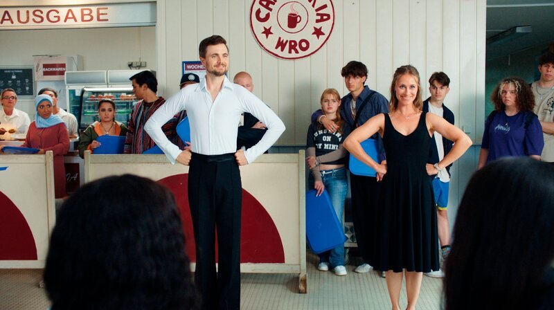 Stimpel (Phil Laude) und Lisa-Britt (Sina Tkotsch) wollen die Schüler:innen im Paartanz weiterbilden. – Bild: SWR/​Clara Marnette