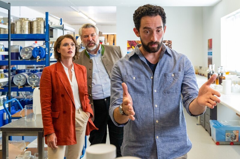 Simon Haflinger (Adrian Moskowicz, r.), ein Mitarbeiter des Duftlabors des Opfers, gibt den Kommissaren Stadler (Dieter Fischer, M.) und Andresen (Sophie Melbinger, l.) zu verstehen, dass seine Expertise wesentlich zum Erfolg der Firma beitrug. – Bild: ZDF /​ ORF /​ Linda Gschwentner