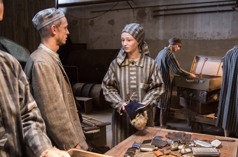 Eva (Natálie Vágnerová) will von Tomasz (Mateusz Dopieralski) in der Kanada-Baracke des KZ Auschwitz wissen, was mit ihren Freunden aus dem Kinderchor von Theresienstadt passiert ist. – Bild: SWR