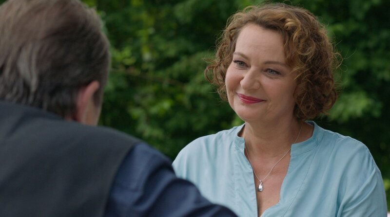 Frau Maierhofer (Lilly Forgách, r.) überbringt Benedikt Beissl (Andreas Giebel, l.) Informationen für seinen Fall. – Bild: ARD/​Sascha Ersfeld